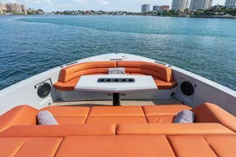 Slide: The Image of Luxury Vanquish VQ58 yacht interior with orange seating, table, and ocean view. - 6