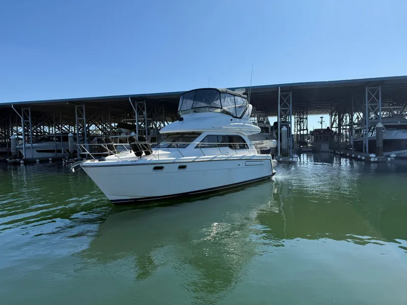 The Image of 2001 Bayliner 3488 Command Bridge Motoryacht docked in marina under clear blue sky. - 0