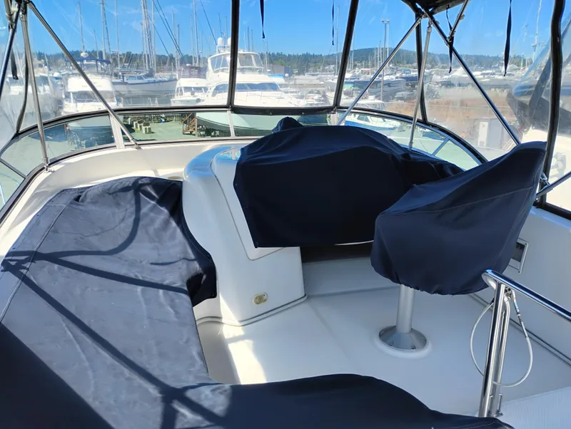 Slide: The Image of 2001 Bayliner 3488 Command Bridge Motoryacht interior with covered seating and marina view. - 13