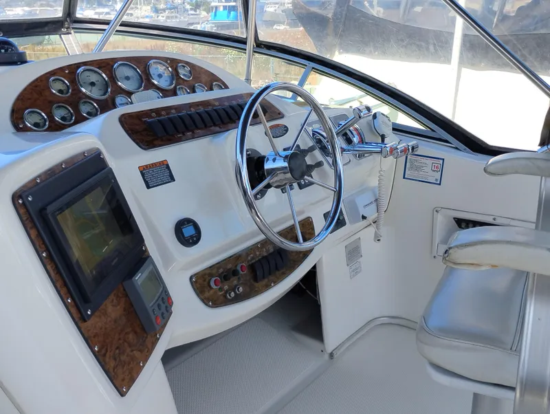 Slide: The Image of 2001 Bayliner 3488 Command Bridge Motoryacht helm with steering wheel and control panel. - 19