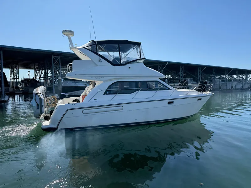 Slide: The Image of 2001 Bayliner 3488 Command Bridge Motoryacht on calm water near marina. - 2