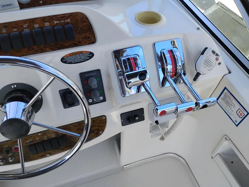 Slide: The Image of 2001 Bayliner 3488 Command Bridge Motoryacht helm with steering wheel and throttle controls. - 20
