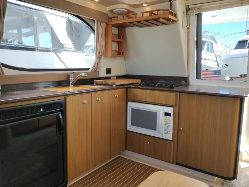 Slide: The Image of 2001 Bayliner 3488 Command Bridge Motoryacht interior kitchen with wood cabinets and modern appliances. - 28