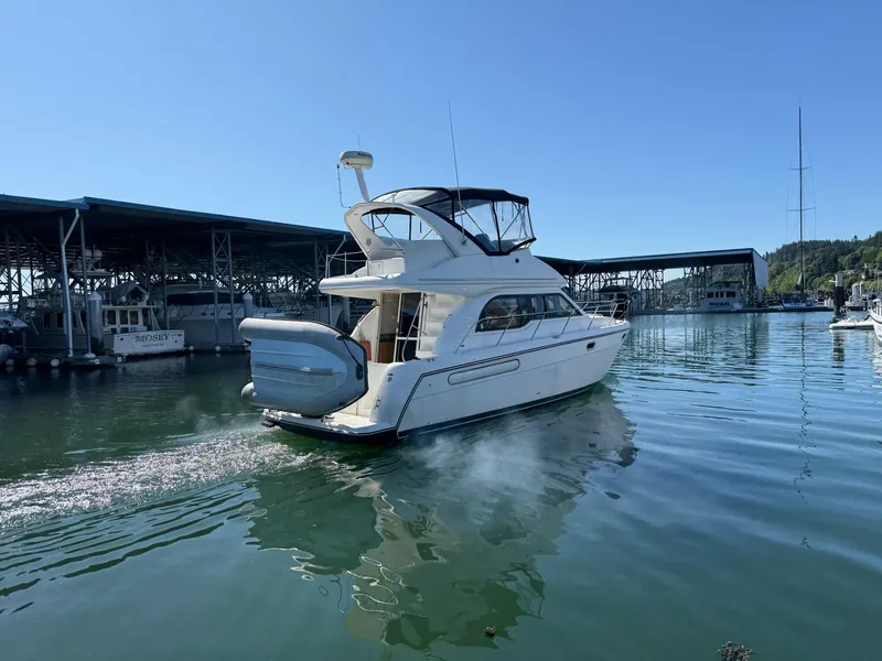 Slide: The Image of 2001 Bayliner 3488 Command Bridge Motoryacht cruising in a marina under clear blue skies. - 3