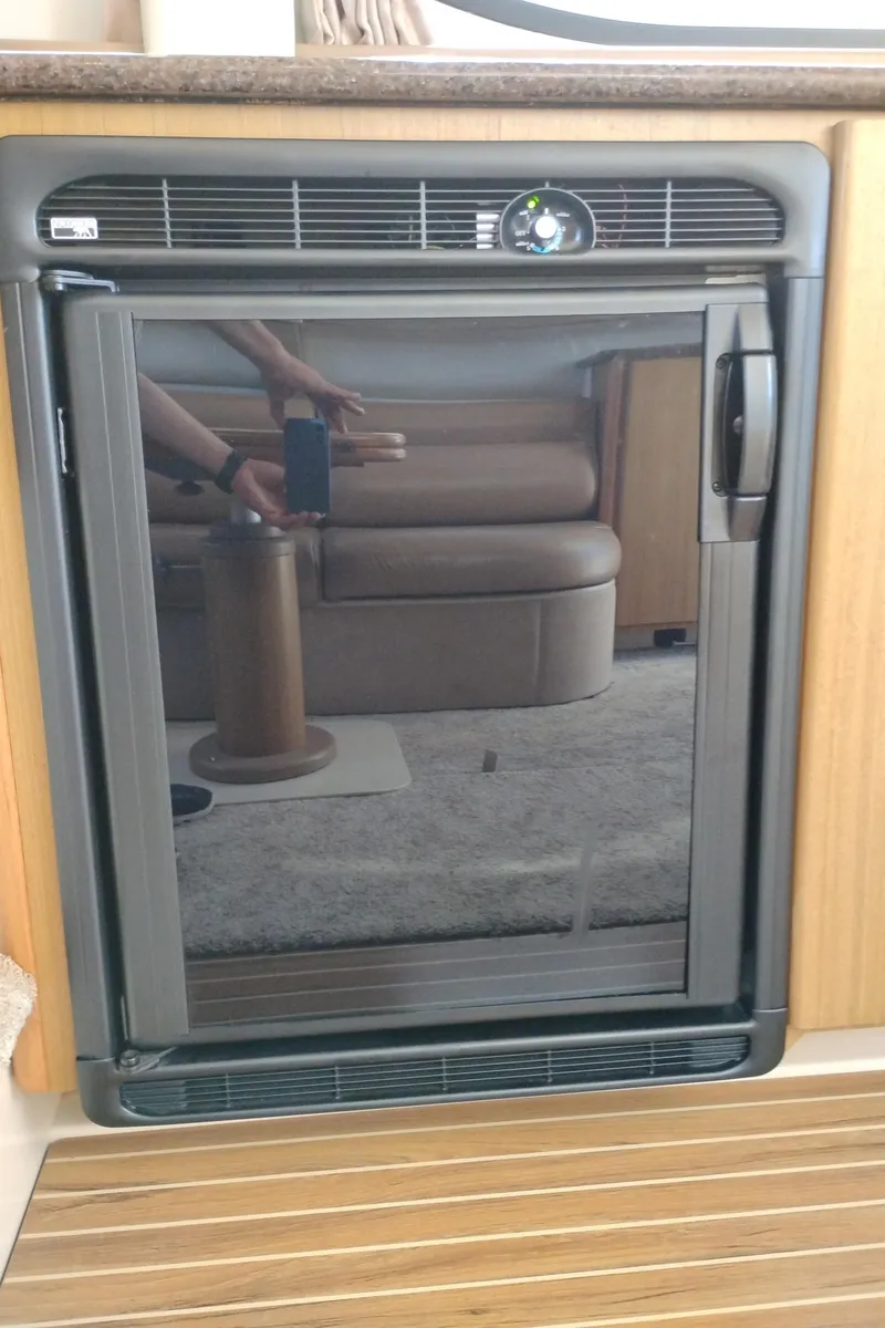 Slide: The Image of Mini fridge inside 2001 Bayliner 3488 Command Bridge Motoryacht, reflecting interior seating area. - 32