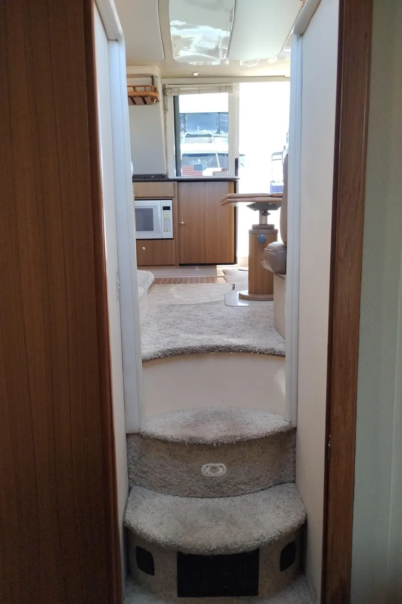 Slide: The Image of Interior view of 2001 Bayliner 3488 Command Bridge Motoryacht, featuring carpeted steps and kitchenette. - 41