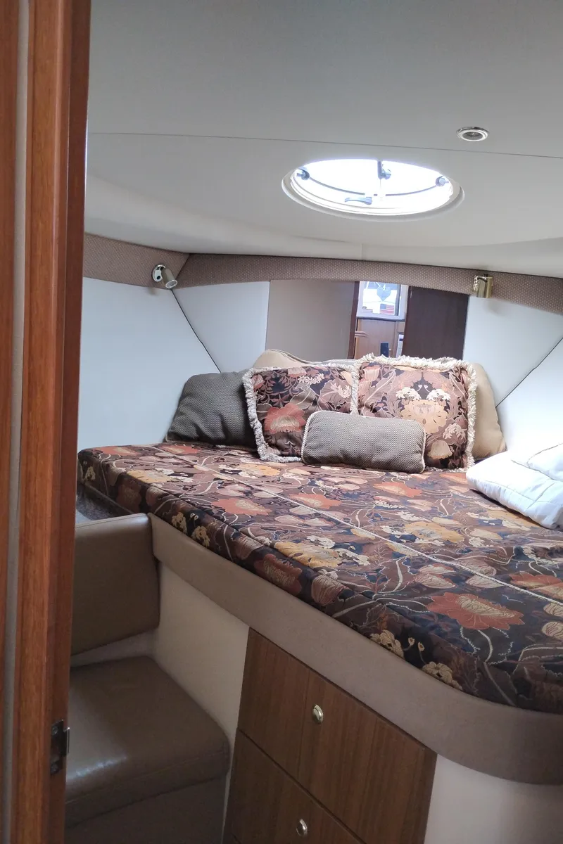 Slide: The Image of 2001 Bayliner 3488 Command Bridge Motoryacht cabin with floral bedding and porthole window. - 44