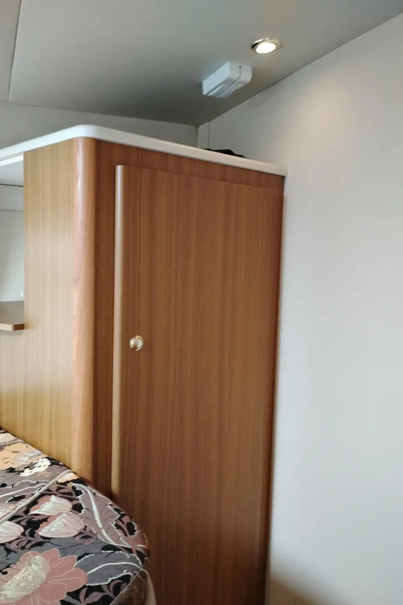 Slide: The Image of Interior of 2001 Bayliner 3488 Command Bridge Motoryacht with wood cabinet and floral bedding. - 49