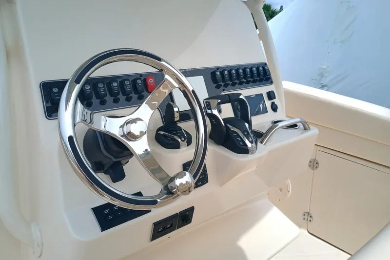 Slide: The Image of 2025 Grady-White Canyon 271 boat dashboard with steering wheel and controls. - 14