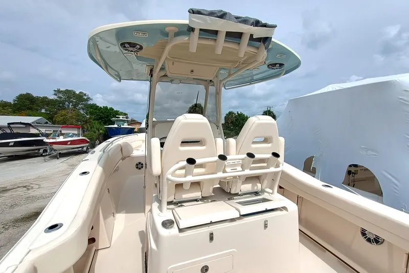 Slide: The Image of 2025 Grady-White Canyon 271 boat interior with seating and console, docked outdoors. - 9