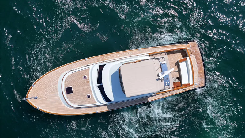 Slide: The Image of Aerial view of a 2005 San Juan SJ 48 Flybridge on the water, featuring an elegant wood deck. - 26