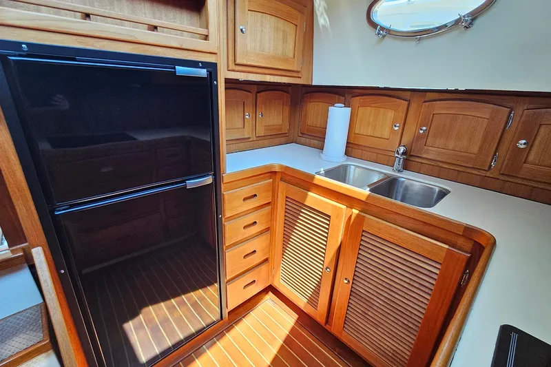 Slide: The Image of Luxurious 2005 San Juan 48 yacht kitchen with wood cabinetry and modern appliances. - 62