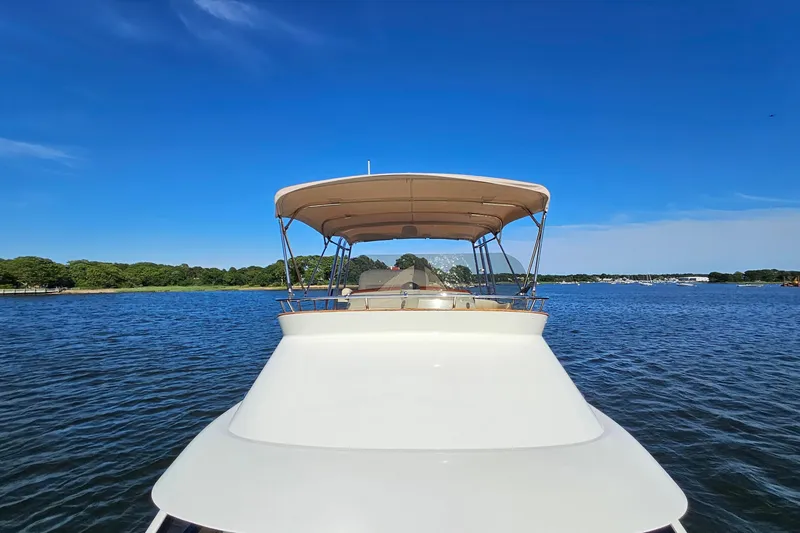 Slide: The Image of 2005 San Juan SJ 48 Flybridge yacht on calm water under clear blue sky. - 30