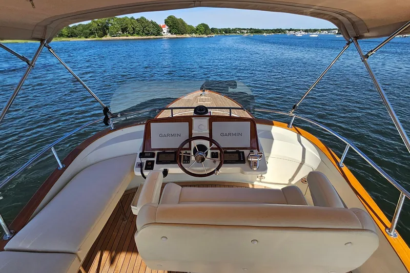 Slide: The Image of Flybridge view of 2005 San Juan SJ 48, featuring Garmin navigation, cruising on serene waters. - 38