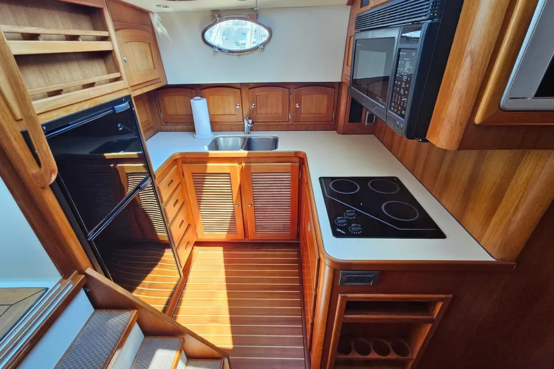 Slide: The Image of Luxurious 2005 San Juan 48 yacht kitchen with wood cabinetry, modern appliances, and sleek design. - 60