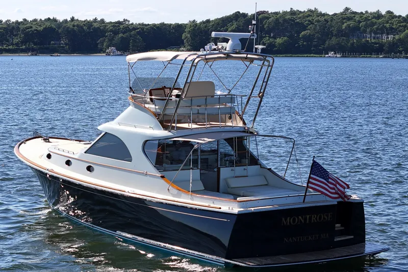 Slide: The Image of 2005 San Juan SJ 48 Flybridge yacht on water, American flag, sunny day. - 21