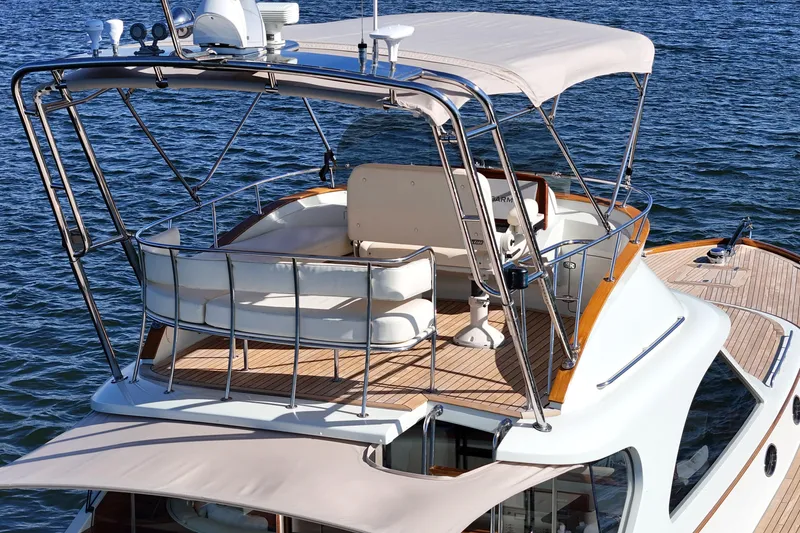 Slide: The Image of 2005 San Juan SJ 48 Flybridge yacht with elegant seating and canopy on water. - 14
