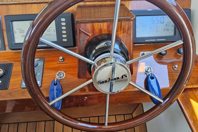 Slide: The Image of Steering wheel of a 2005 San Juan 48 yacht with electronic controls and wood finish. - 54