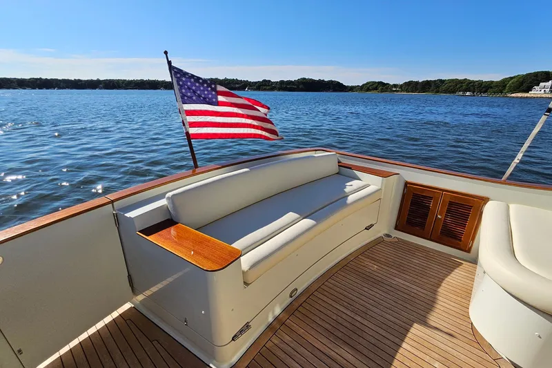 Slide: The Image of 2005 San Juan SJ 48 Flybridge yacht with American flag, scenic water view. - 33