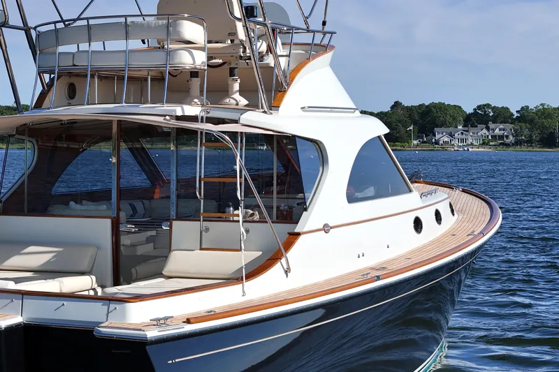 Slide: The Image of Luxurious 2005 San Juan SJ 48 Flybridge yacht on serene water, showcasing elegant design. - 16
