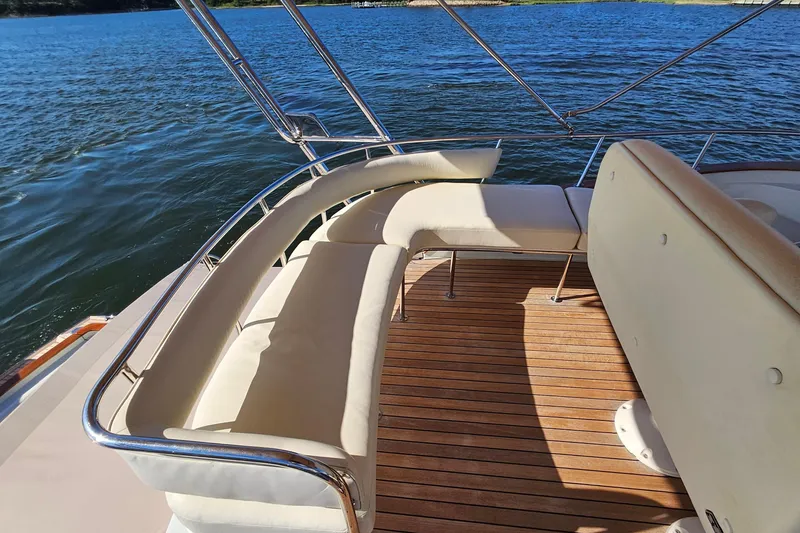 Slide: The Image of Luxurious seating on 2005 San Juan SJ 48 Flybridge yacht with teak deck, overlooking serene waters. - 39
