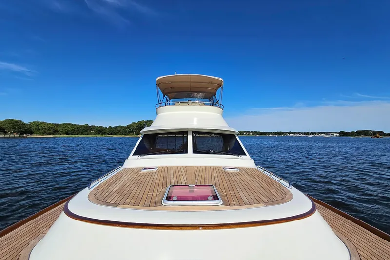 Slide: The Image of San Juan SJ 48 Flybridge yacht on calm water, showcasing sleek design and spacious deck. - 31