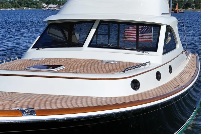 Slide: The Image of 2005 San Juan SJ 48 Flybridge yacht with wooden deck, docked on a serene lake. - 19