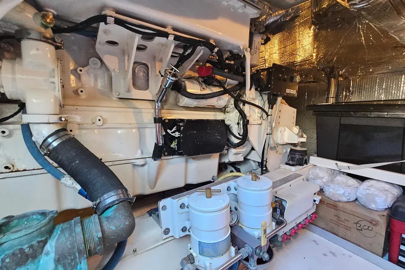 Slide: The Image of Engine room of a 2005 San Juan 48 yacht, showcasing mechanical components and wiring. - 85