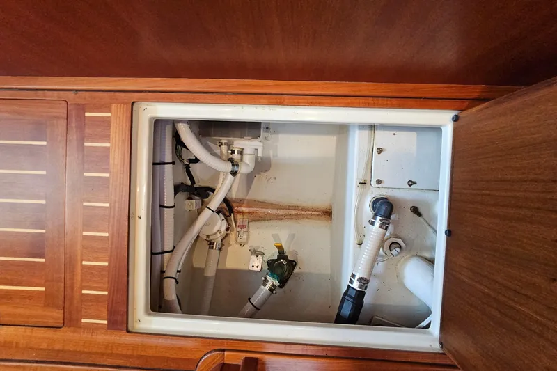 Slide: The Image of Engine compartment of a 2005 San Juan 48 boat, featuring hoses and fittings. - 77