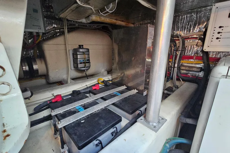Slide: The Image of Engine room of 2005 San Juan 48 yacht, showcasing batteries and wiring. - 80