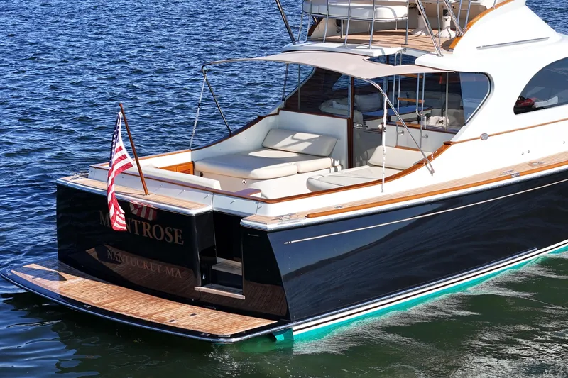 Slide: The Image of Luxury 2005 San Juan SJ 48 Flybridge yacht on water, featuring elegant design and American flag. - 13