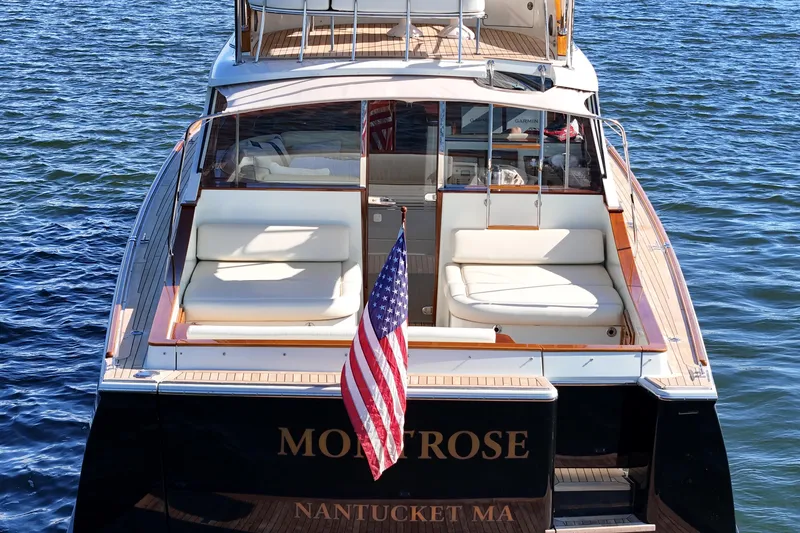Slide: The Image of San Juan SJ 48 Flybridge 2005 yacht on water, rear view with American flag. - 12
