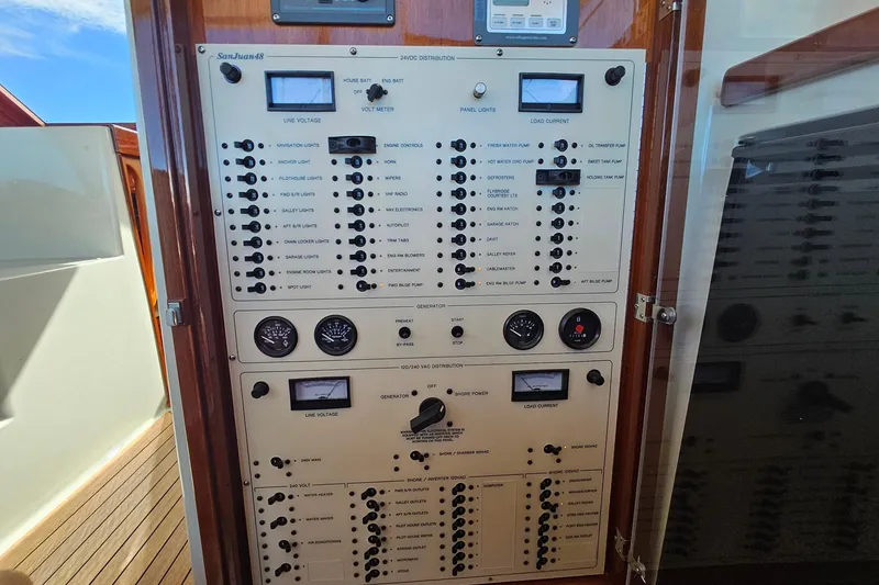 Slide: The Image of Electrical control panel on a 2005 San Juan 48 yacht, featuring various switches and gauges. - 47