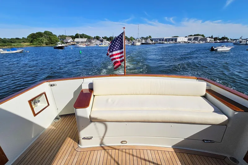 Slide: The Image of 2005 San Juan SJ 48 Flybridge yacht with American flag, cruising on a sunny day. - 32