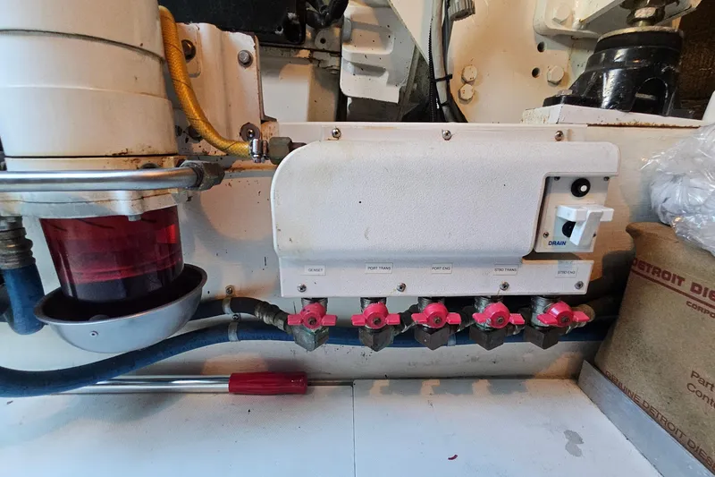 Slide: The Image of Engine room of a 2005 San Juan 48 boat, featuring fuel valves and filter system. - 86