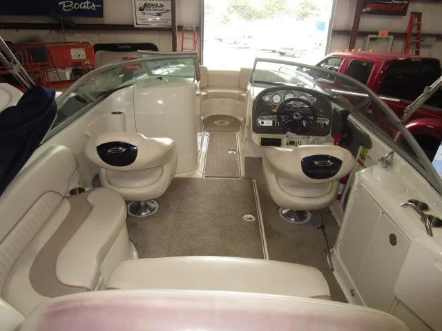 Slide: The Image of 2007 Azure AZ220 deckboat interior with beige seating and steering console in a showroom. - 6
