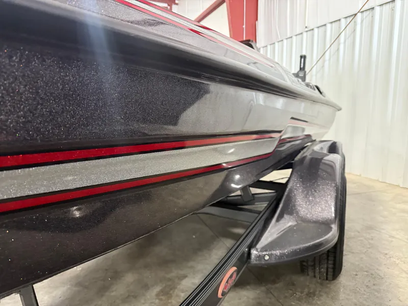 Slide: The Image of 2018 Bass Cat Eyra boat with sleek metallic finish and red accents in a garage. - 12