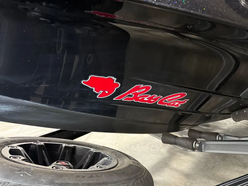 Slide: The Image of 2018 Bass Cat Eyra boat with logo, black hull, and trailer wheel visible. - 14