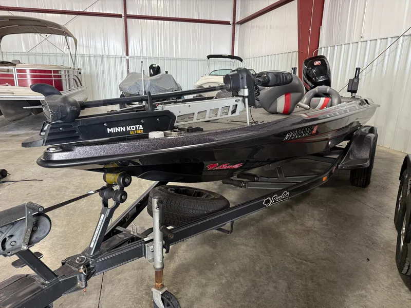 Slide: The Image of 2018 Bass Cat Eyra fishing boat with Minn Kota Ultrex motor in a storage facility. - 2