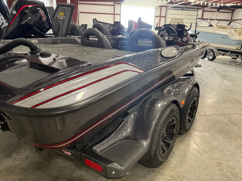 Slide: The Image of 2018 Bass Cat Eyra boat in showroom, featuring sleek design and dual-axle trailer. - 4