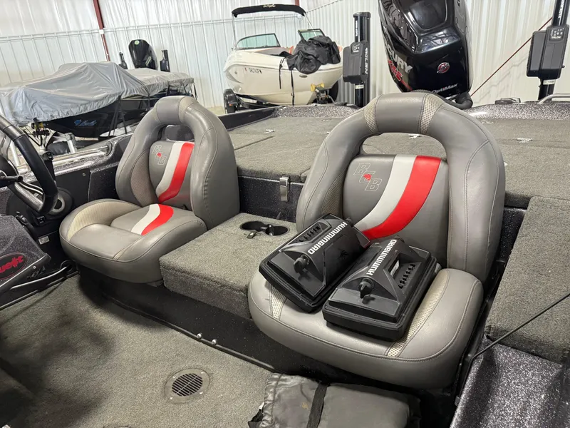 Slide: The Image of 2018 Bass Cat Eyra boat interior with gray and red seats, Humminbird electronics, and Mercury engine. - 9
