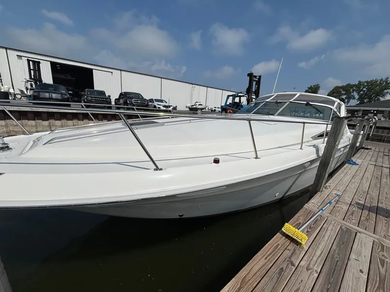 Slide: The Image of 1992 Sea Ray 400 EXPRESS docked at marina, showcasing sleek white design and spacious deck. - 4