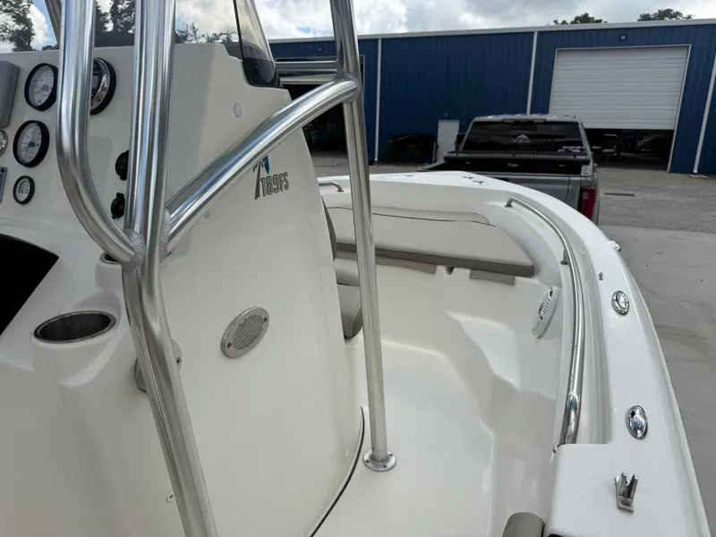 Slide: The Image of 2022 Key West 189FS boat interior with console, gauges, and seating, parked near a blue building. - 11