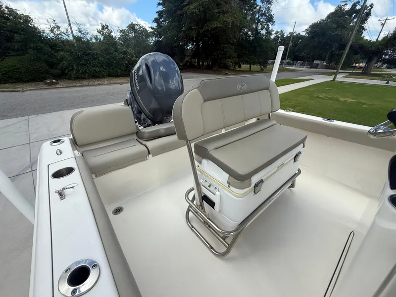 Slide: The Image of 2022 Key West 189FS boat interior with seating and motor, parked outdoors. - 17