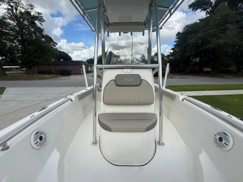 Slide: The Image of 2022 Key West 189FS boat interior with seating and console, parked outdoors. - 20