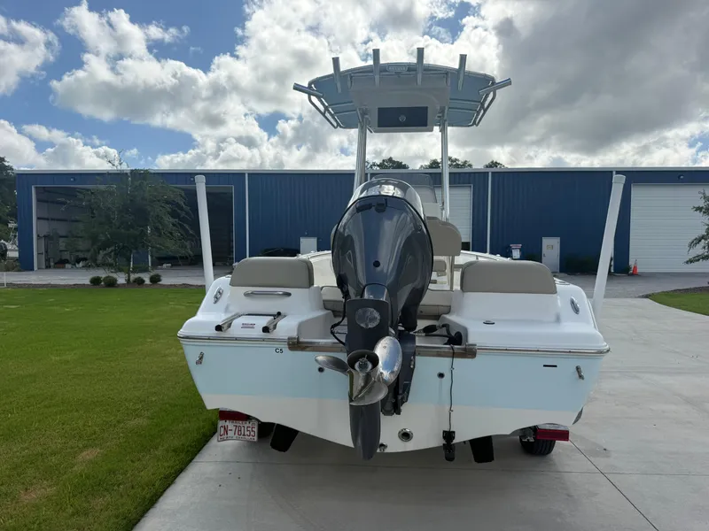 Slide: The Image of 2022 Key West 189FS boat with outboard motor, parked on concrete near blue building. - 6