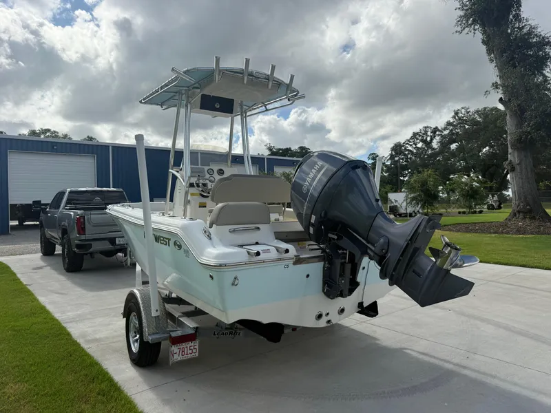 Slide: The Image of 2022 Key West 189FS boat on trailer, parked near a truck, under cloudy sky. - 7