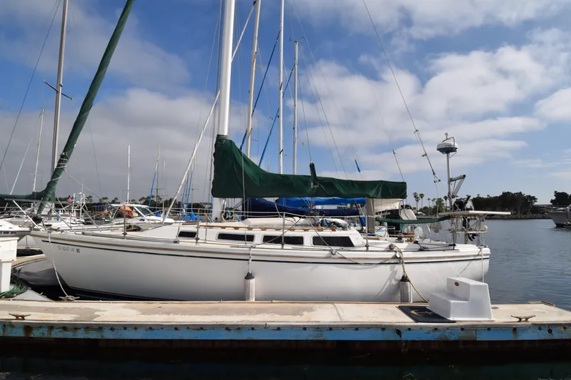 The Image of 1984 Catalina 30 sailboat docked at marina under blue sky. - 0