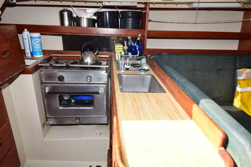 Slide: The Image of 1984 Catalina 30 yacht galley with stove, sink, and countertop essentials. - 3