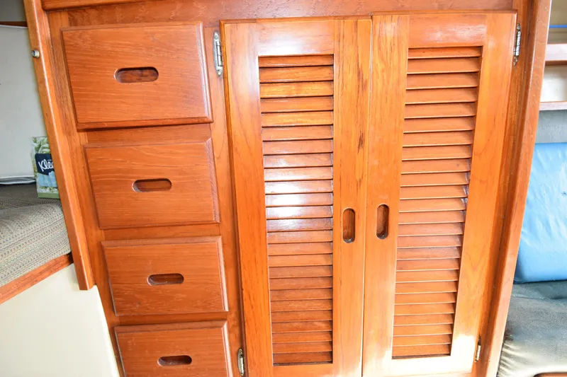 Slide: The Image of Wooden cabinetry inside a 1984 Catalina 30 sailboat, featuring drawers and louvered doors. - 5